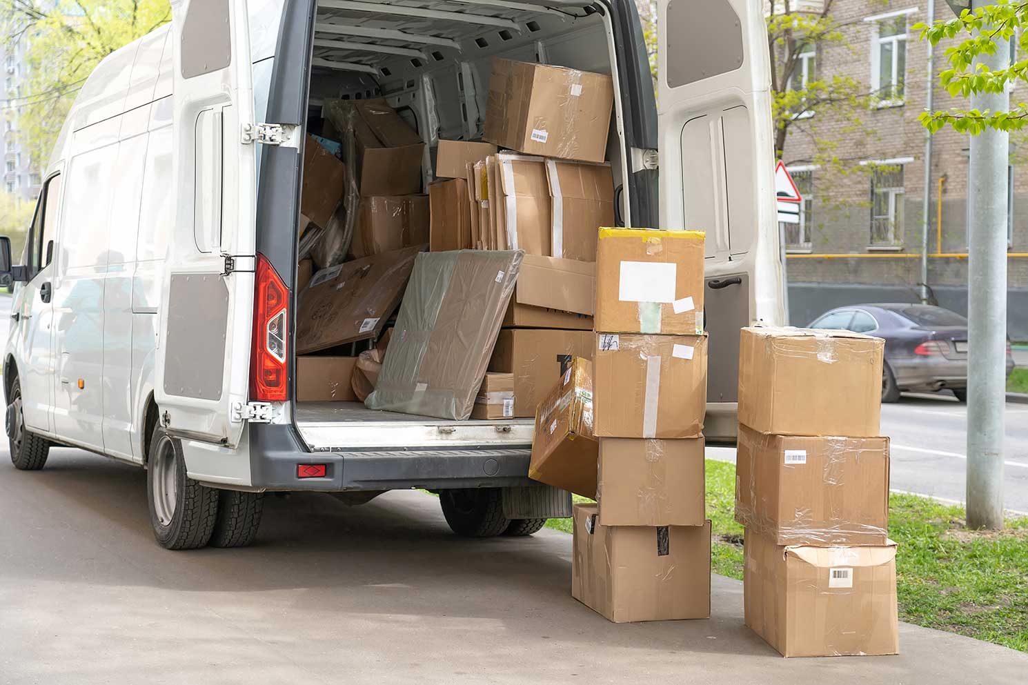 A delivery van overflowing with many large packages.