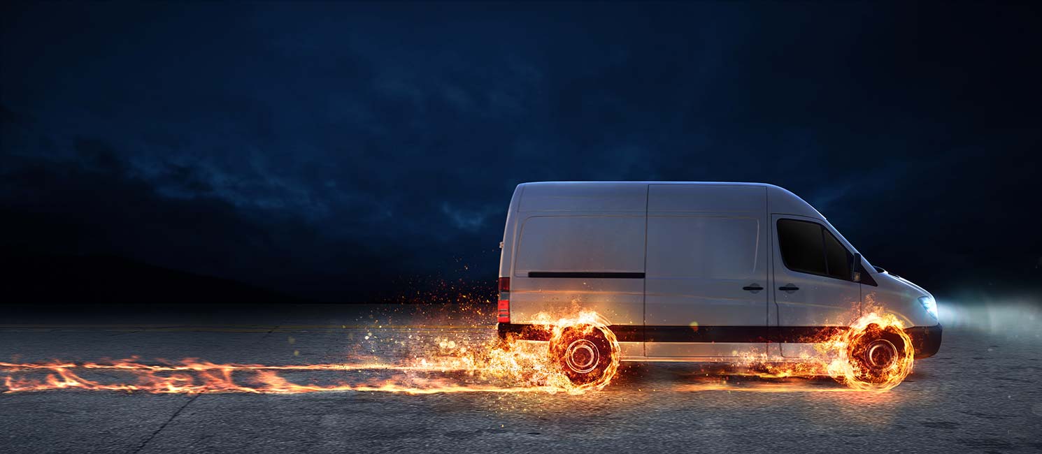 A delivery van going so fast its wheels are on fire.