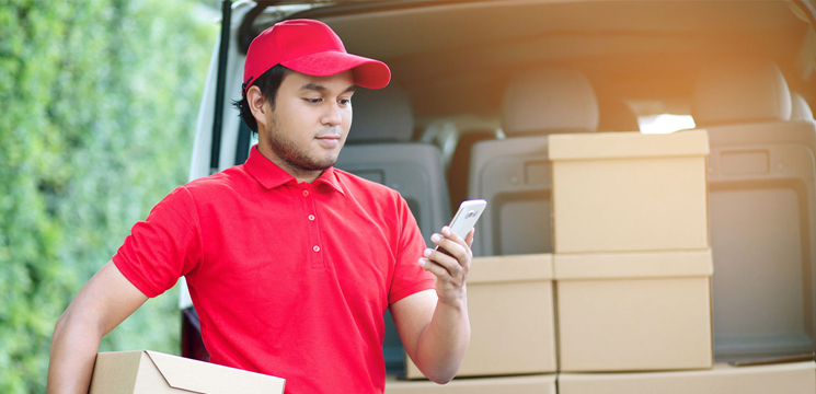 Courier sorts packages in the back of his delivery van.